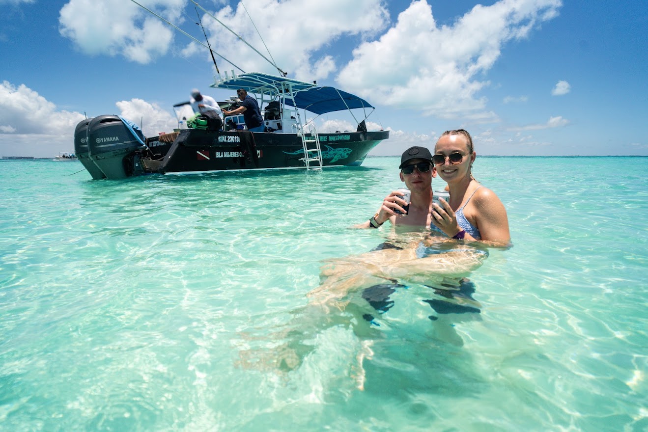 Couple enjoying turquoise waters next to the tour boat